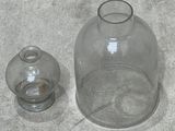 a glass vase and a glass jar sitting on the floor