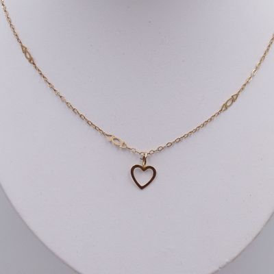 a close up of a gold heart necklace on a mannequin