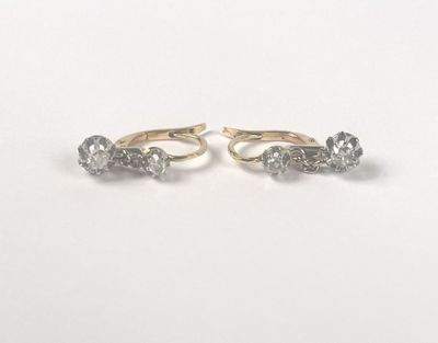 a pair of gold and diamond earrings on a white background