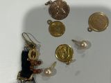 a small collection of gold and silver jewelry on a white surface