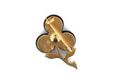 a gold and black flower brooch on a white surface