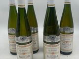 six bouteilles de vin sont alignées sur une surface blanche