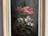 tableau représentant des fleurs roses et blanches, dans un cadre en bois, posé sur une table