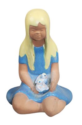 a figurine of a little girl sitting on the ground holding a teddy bear