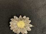 a close up of a silver flower on a black surface