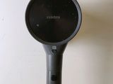 a black hair dryer sitting on top of a white wall