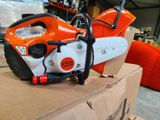 an orange and white chainsaw sitting on top of a cardboard box