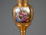 un vase en or orné d'une peinture, posé sur une table
