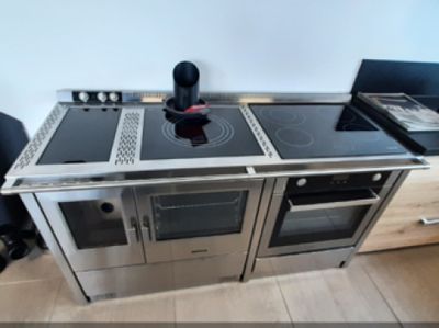 a kitchen with a stove, oven and a laptop on the counter