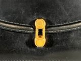 a black purse with a gold clasp on it