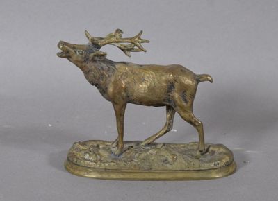 statue en bronze représentant un cerf aux bois imposants, posée sur un socle