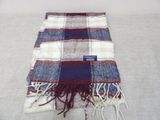 plaid blanket with fringes on a bed with a white and blue blanket