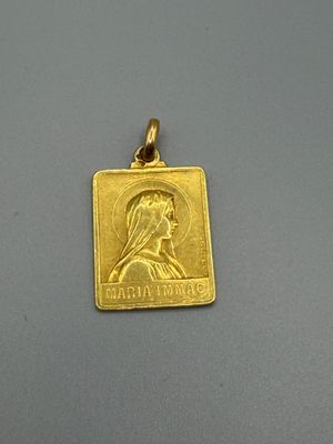 un gros plan d'un pendentif en or orné du portrait d'une femme