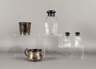 trois bocaux en verre et une coupe en argent posés sur une table