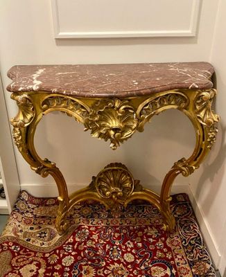 a small table with a marble top on a red carpet