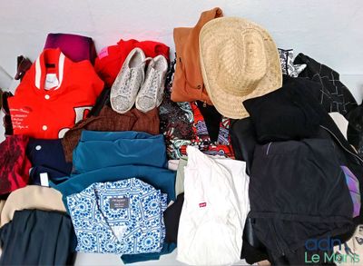 un tas de vêtements et un chapeau posés sur un lit