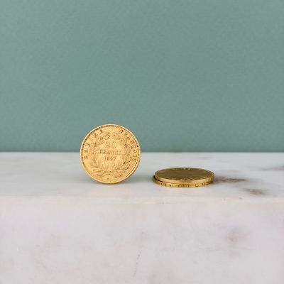 une pièce d'or posée à côté d'une petite pièce d'or