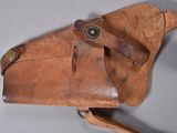 an old leather holster with a leather strap on a gray surface