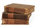trois vieux livres empilés sur une surface blanche