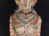 an old wooden statue of a man with a helmet on his head
