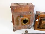 two old cameras are sitting next to each other on a white surface