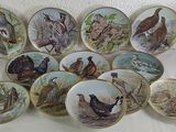 a lot of plates with birds on them on a table