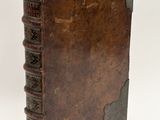 an old book with a brown cover sitting on top of a table