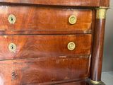 une commode en bois avec un plateau en marbre, posée sur un sol carrelé