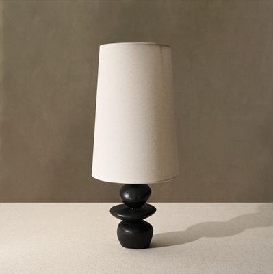 une lampe noire avec un abat-jour blanc posée sur une table
