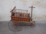 un petit chariot en bois avec un lit à l'arrière