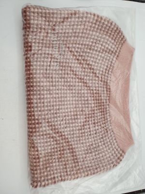 a pink sweater in a plastic bag on a table