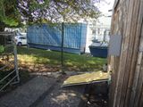 a wooden fence and a metal gate in front of a building
