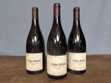 three bottles of wine sitting on top of a wooden table