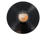 an old record with a label on it sitting on a white surface