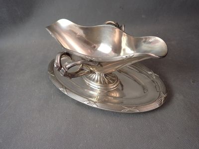 a silver plate with a flower on it on a table
