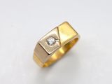 gros plan d'une bague en or avec un diamant au centre