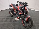 une moto rouge et noire garée dans une pièce