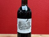 a bottle of red wine sitting on a wooden table