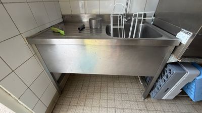 un évier dans un coin de la cuisine, avec une poubelle à l'intérieur