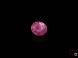 a close up of a pink diamond on a black surface