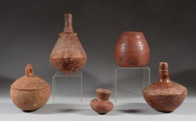 several pieces of pottery are sitting on a stand on a gray surface