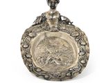 an antique silver plate with a woman holding a fish on it