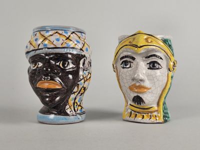 two salt and pepper shakers with faces painted on them