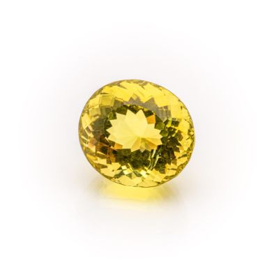 a close up of a yellow sapphire stone on a white surface