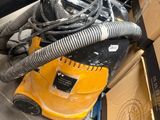 a yellow vacuum cleaner and a box on the floor