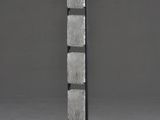 a tall metal sculpture with a wooden base and four squares on it