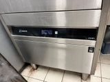 stainless steel dishwasher in a commercial kitchen next to a trash can