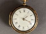 une montre de poche en or avec des chiffres romains sur le cadran