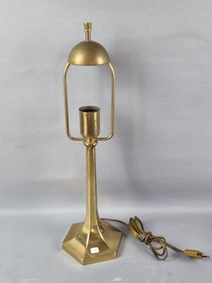 une lampe dorée posée sur une surface blanche