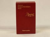 an image of a red box containing a perfume on a white surface